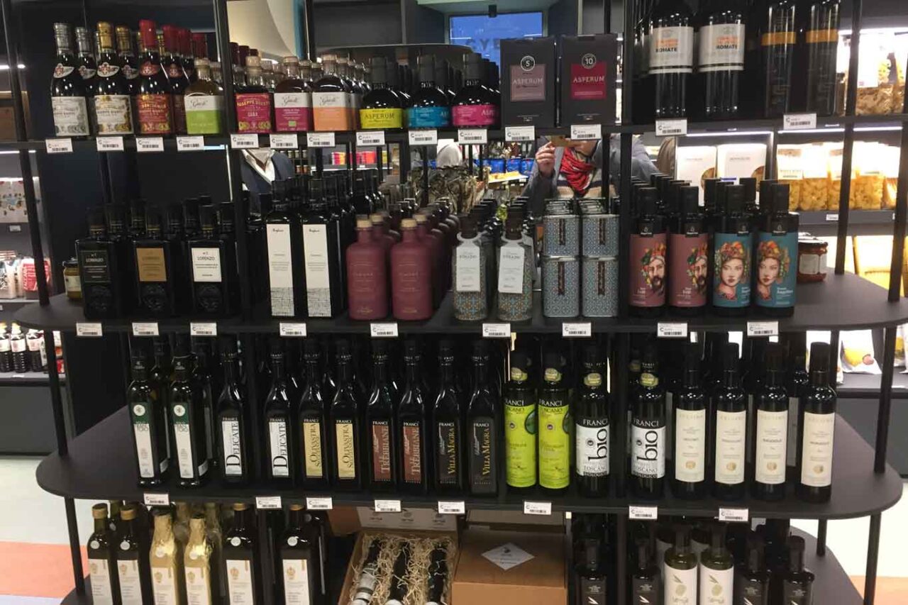 Bottiglie di olio extravergine di oliva nello scaffale di un supermercato