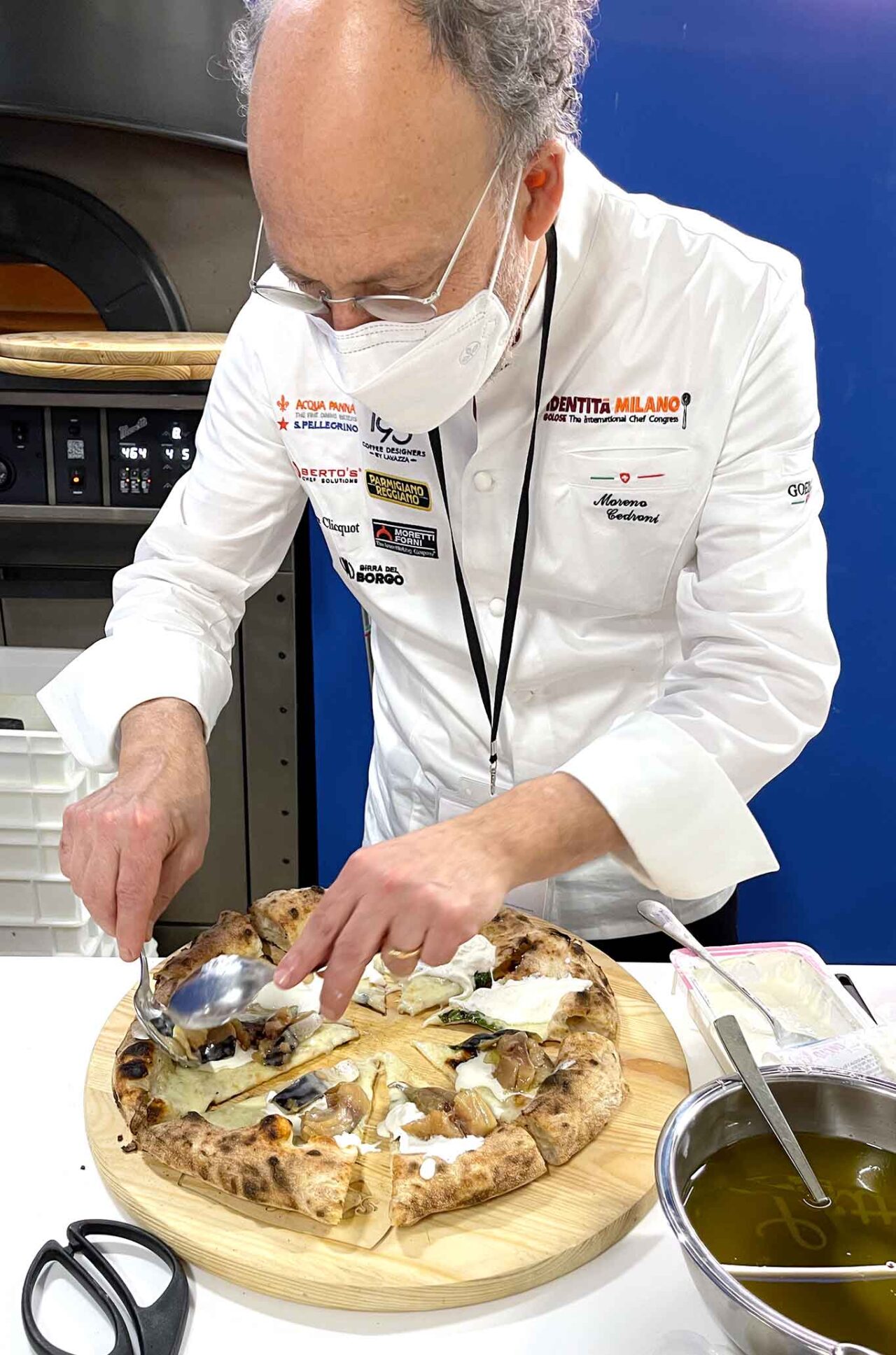 Moreno Cedroni sistema lo sgombro per comporre la pizza con il pesce