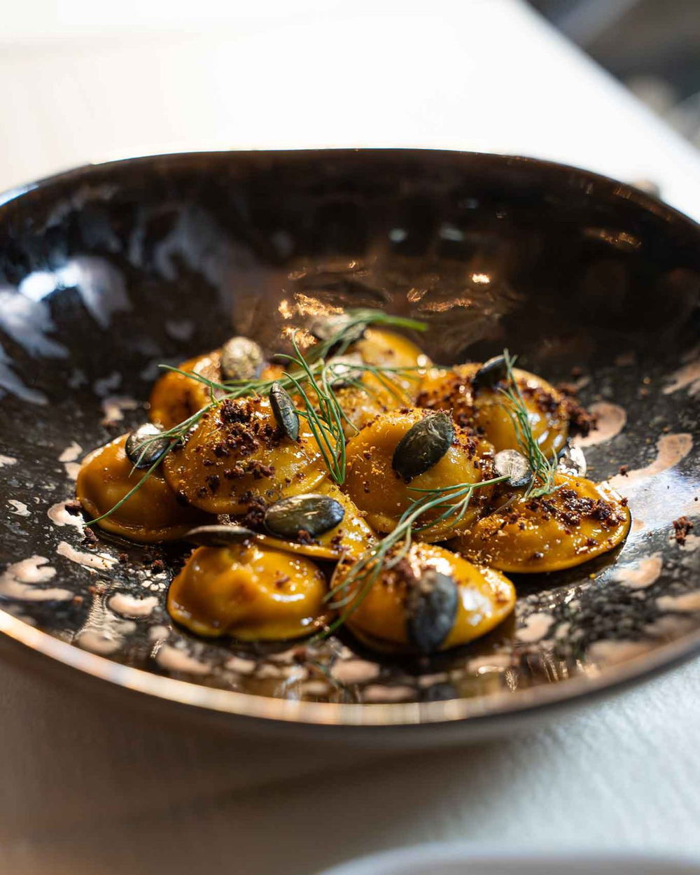 La ricetta dei bottoni ripieni di coniglio alla cacciatora, semi di zucca e oliva disidratata della Locanda del Cardinale ad Assisi